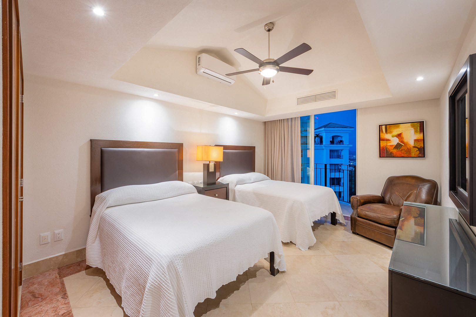 Bedroom with two beds and a reading chair