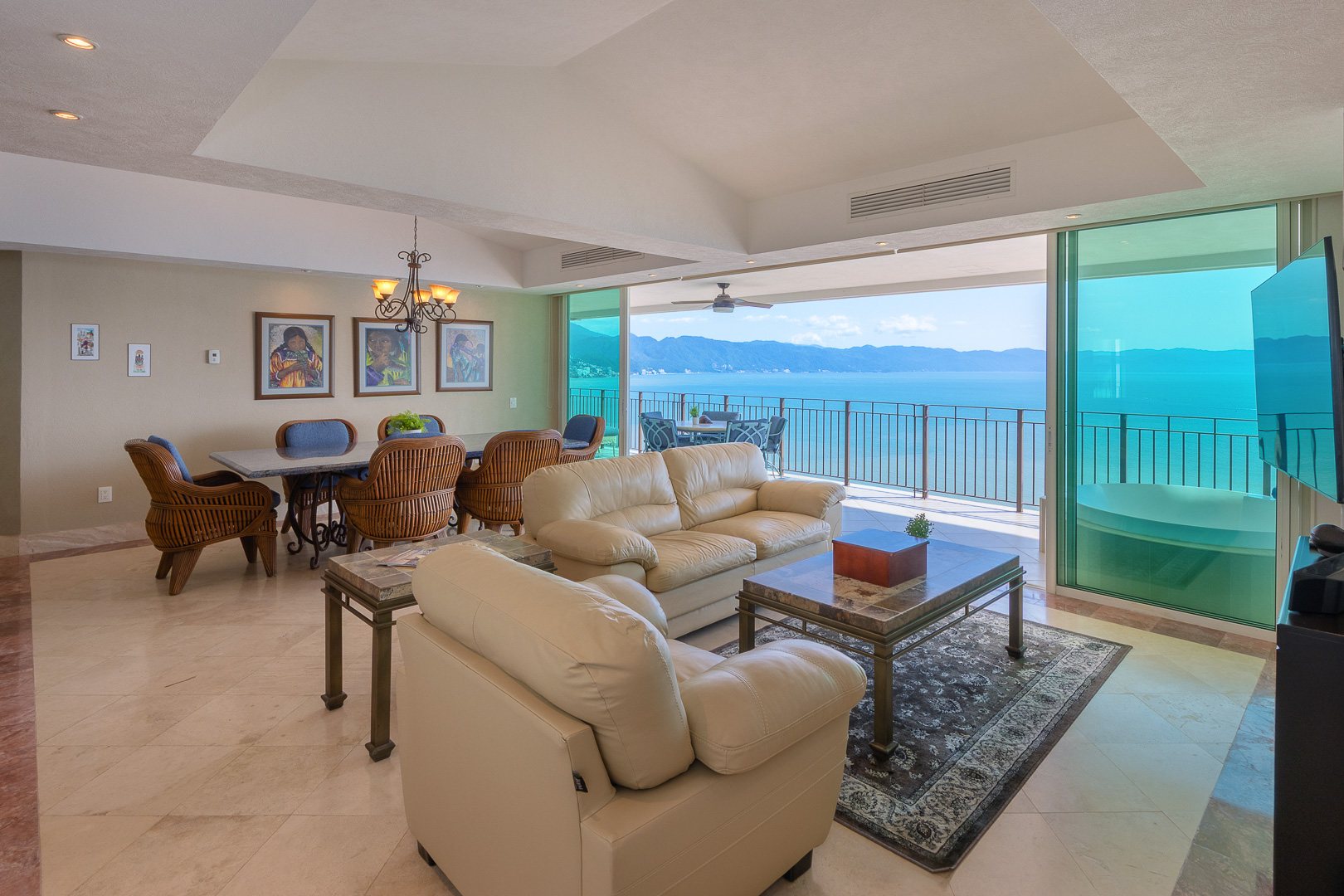 Great room with glass doors open to the ocean terrace
