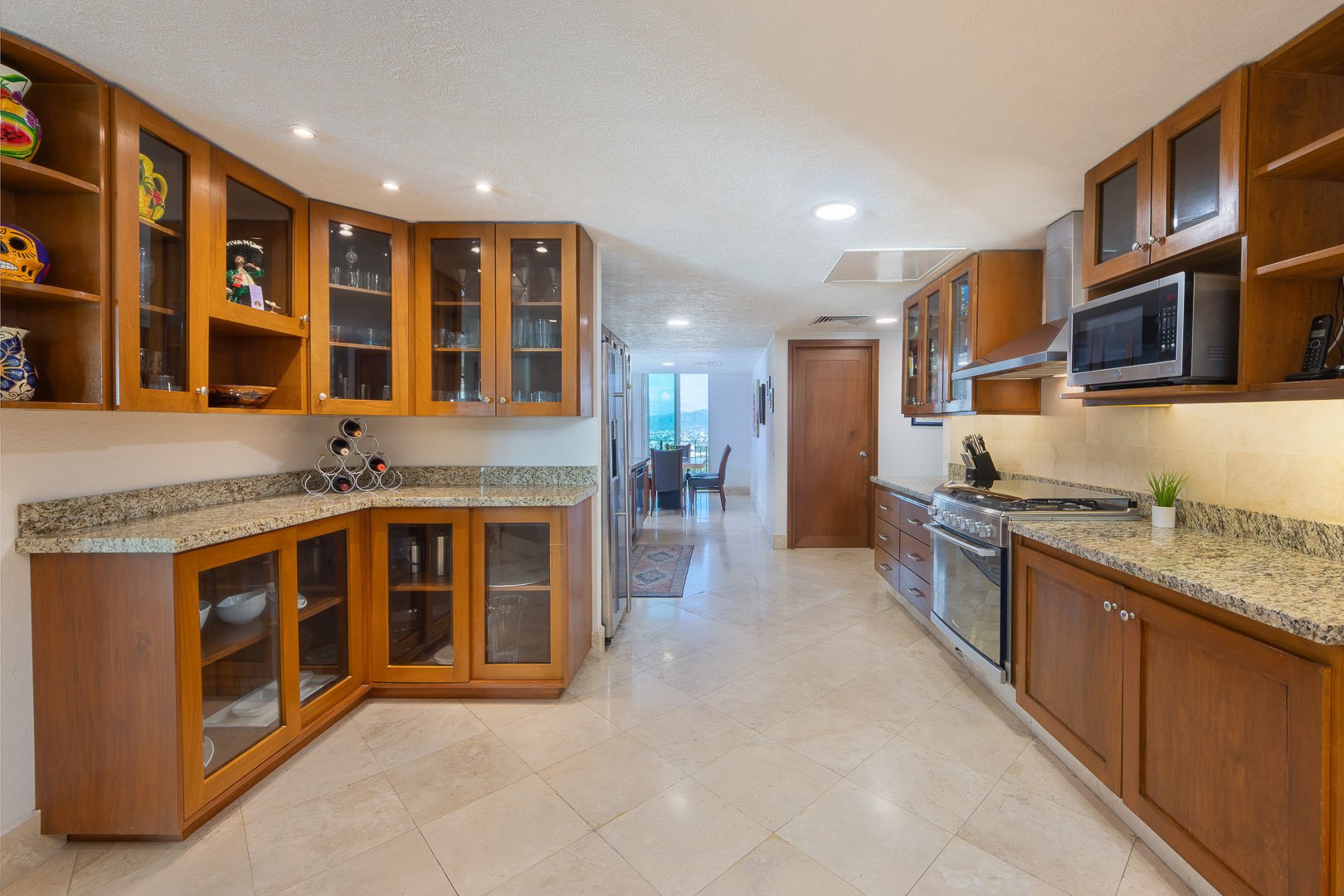 Kitchen with wood cabinetry, granite counters and a gas range