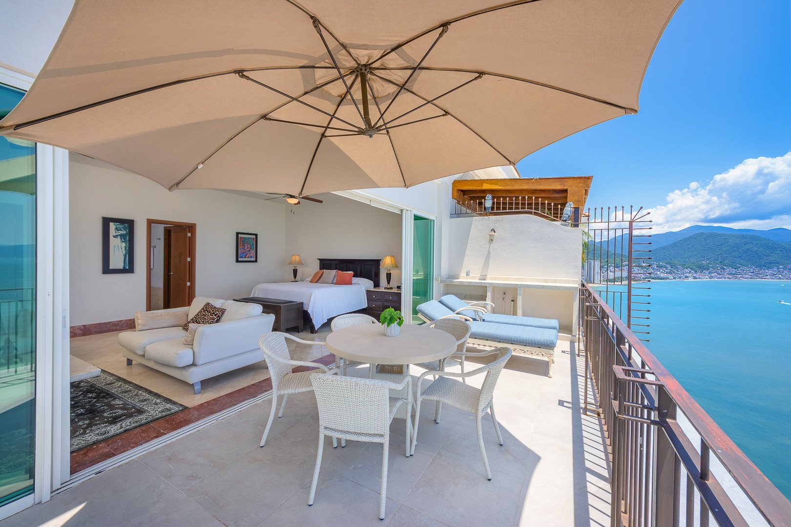 Private terrace of the primary suite with dining table and umbrella