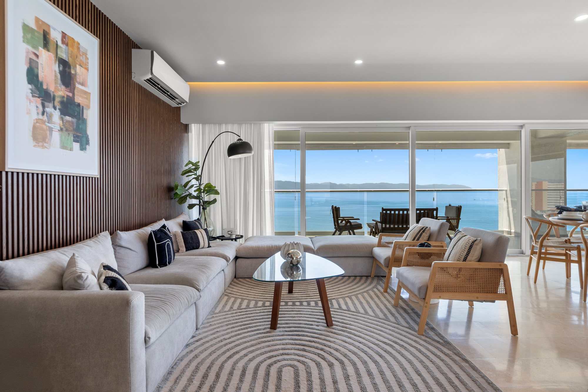 Sala con sofá seccional y vista al mar
