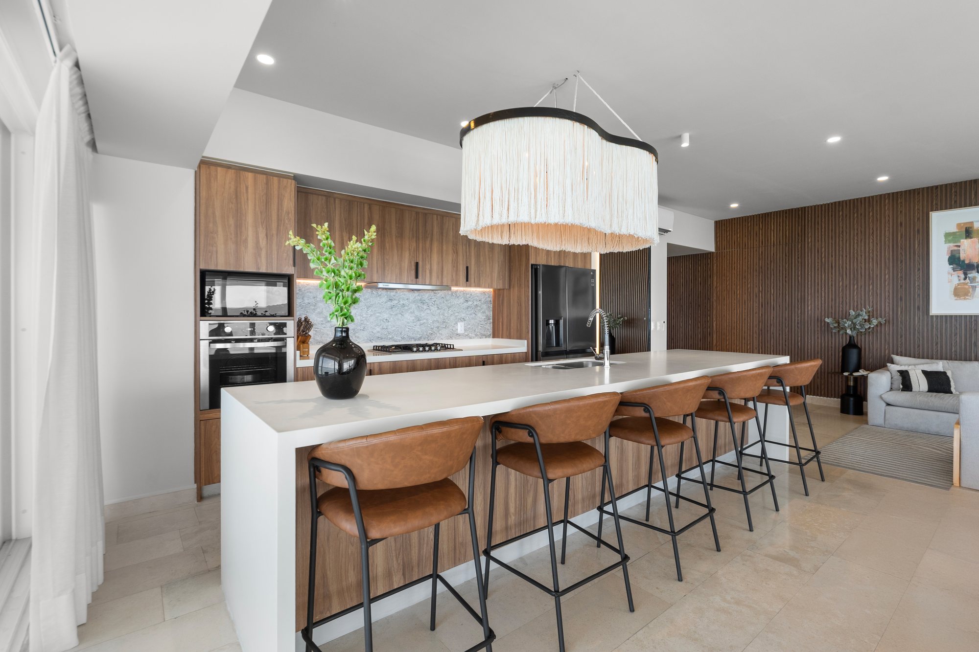 Cocina de diseño con isla larga y electrodomésticos de alta gama