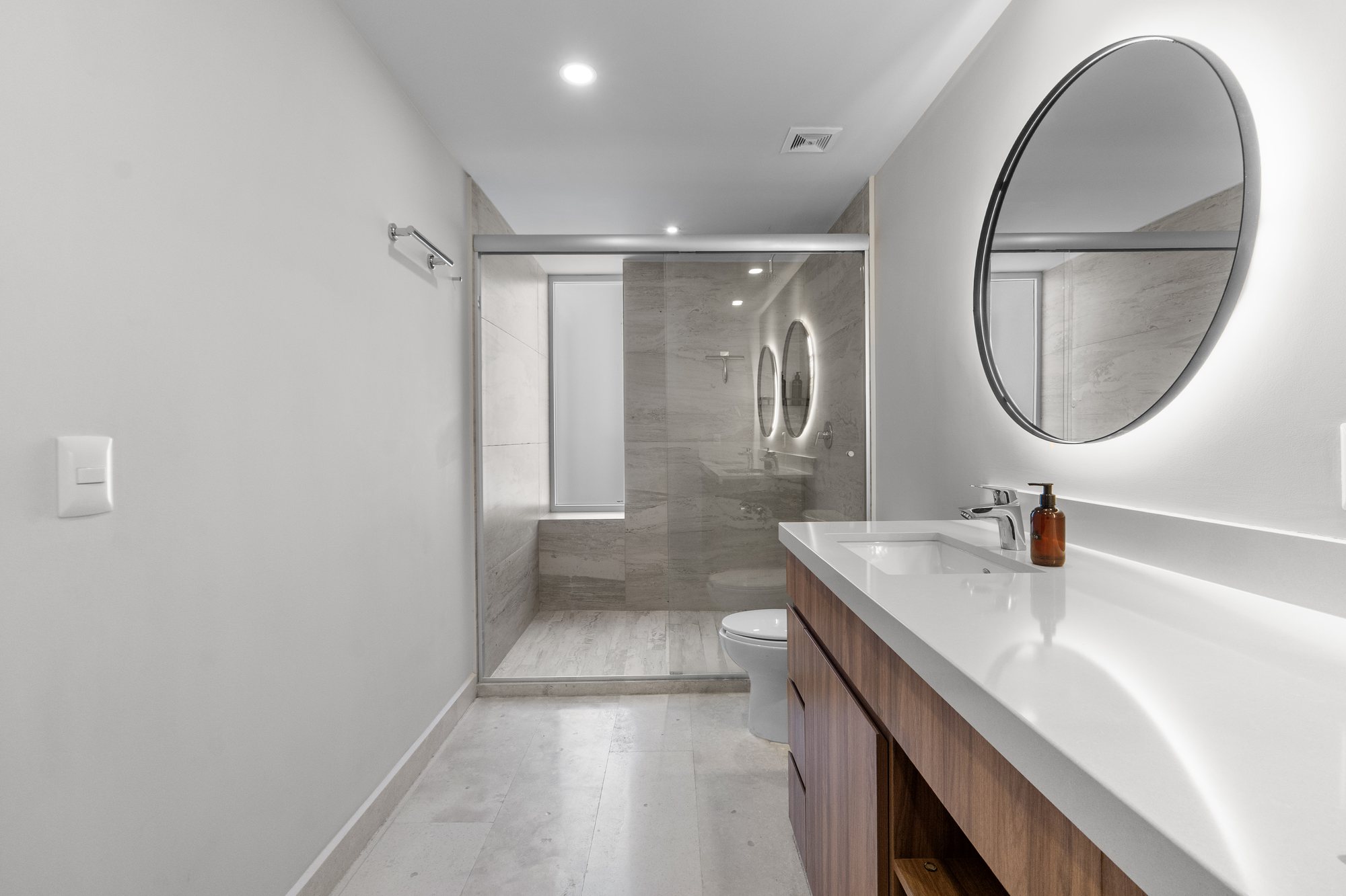 Baño con lavabo amplio y regadera de cristal