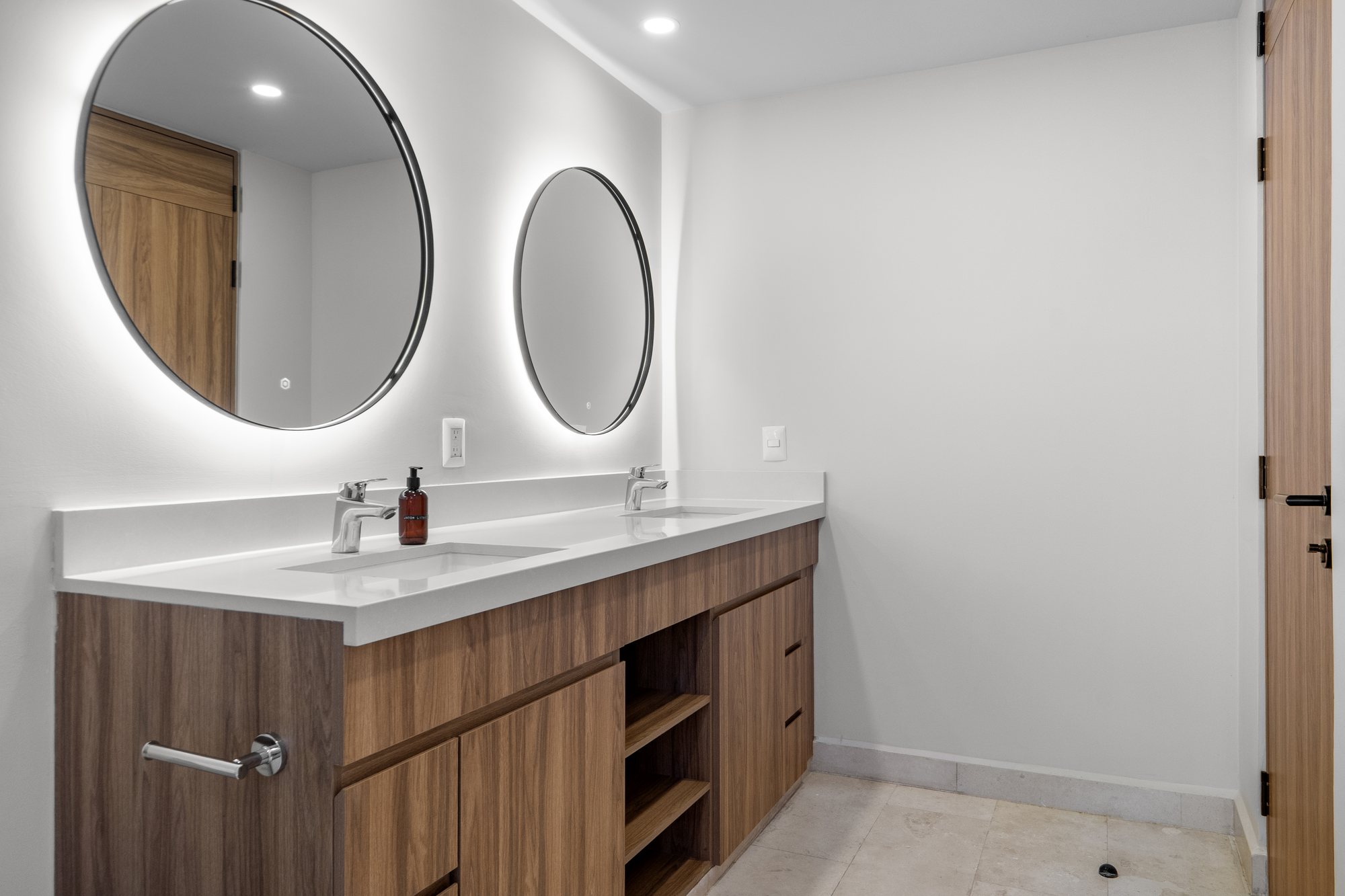 Baño con doble lavabo y espejos iluminados