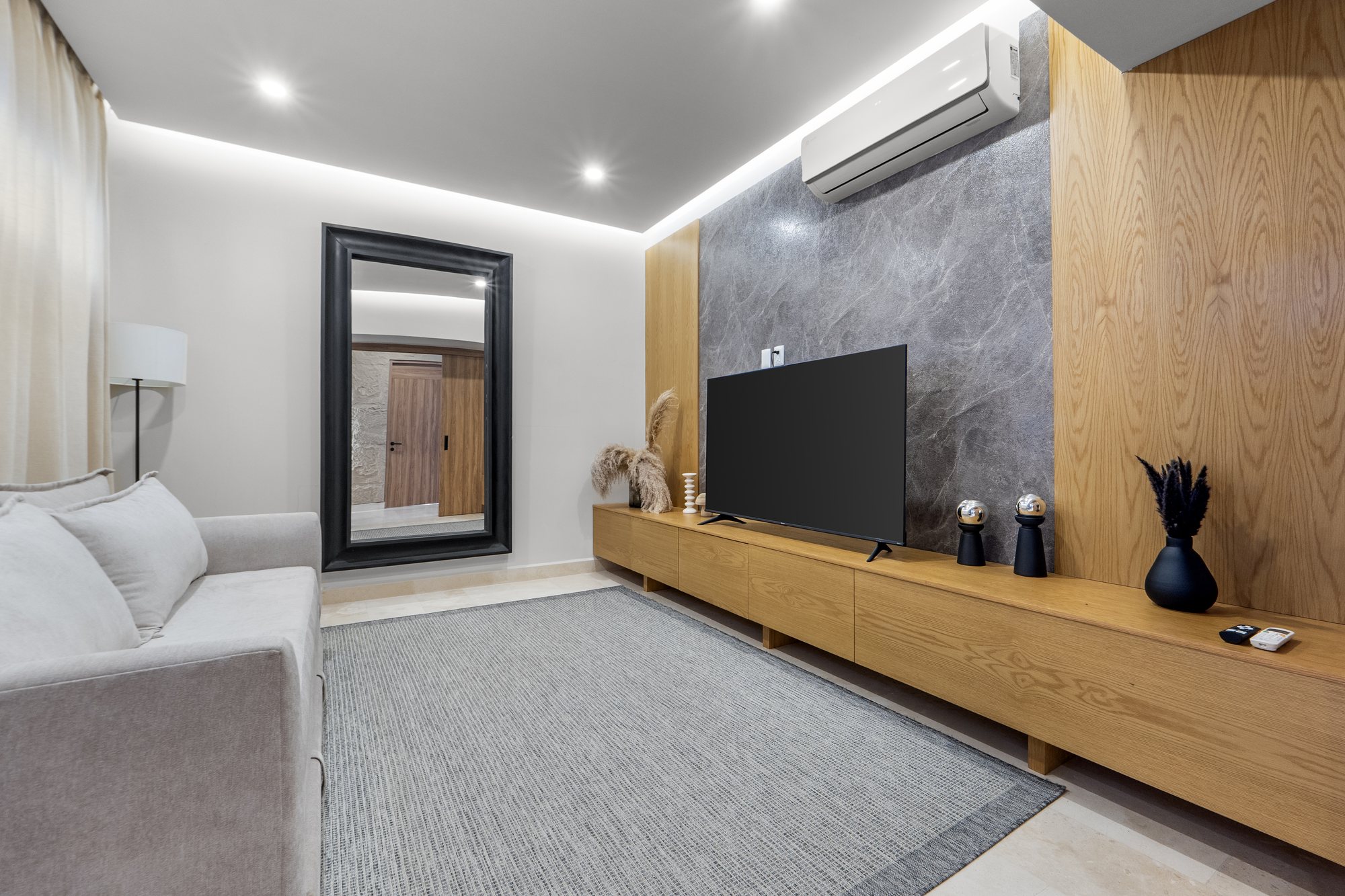 Sala de TV con muro de madera y piedra