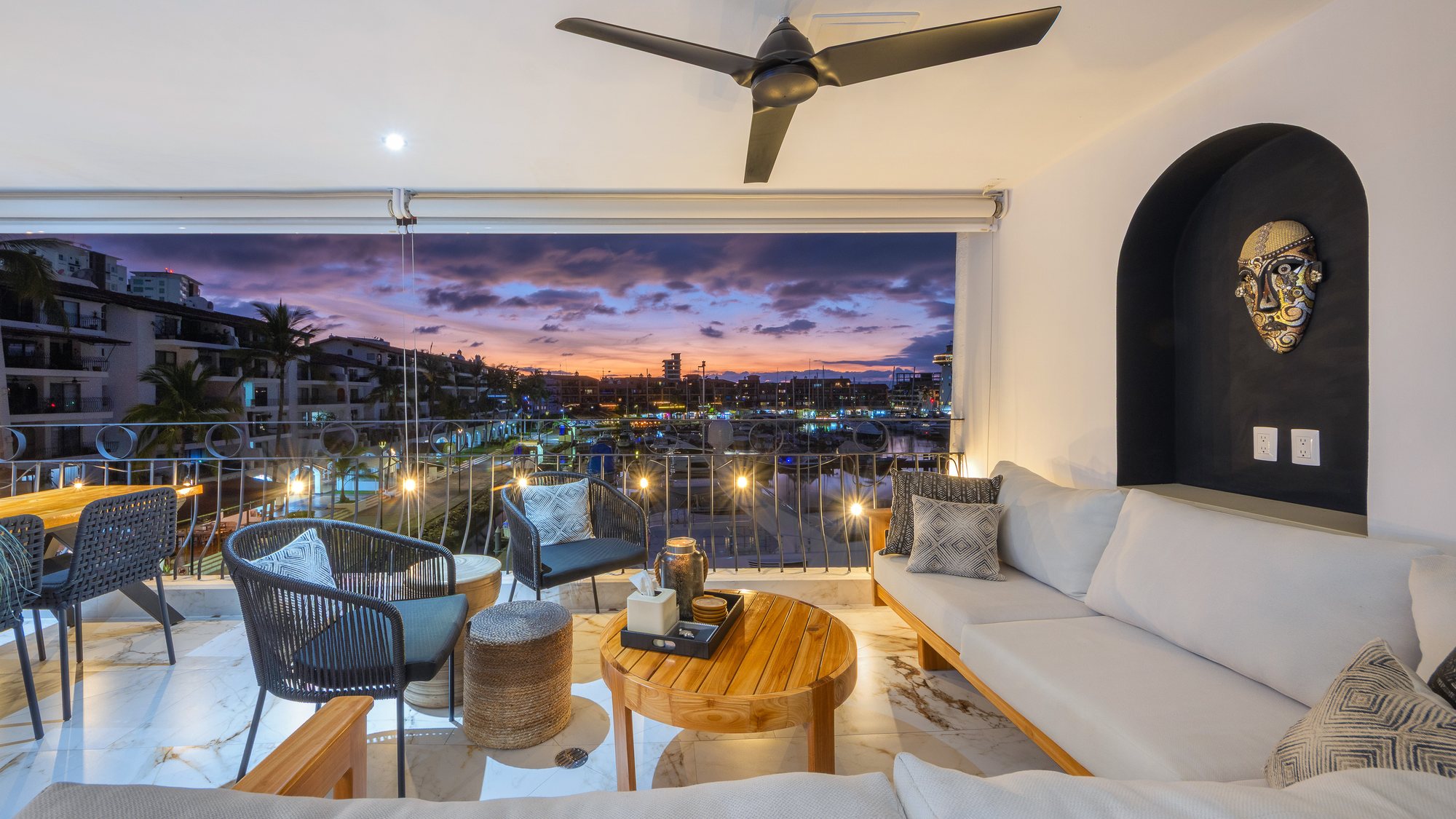 Sala de la terraza techada frente a la marina al anochecer