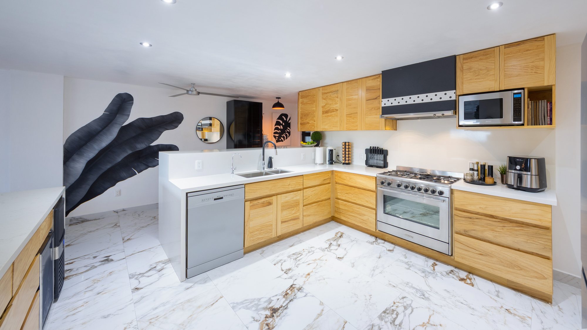 Cocina con gabinetes de madera, cubiertas de cuarzo y estufa de gas