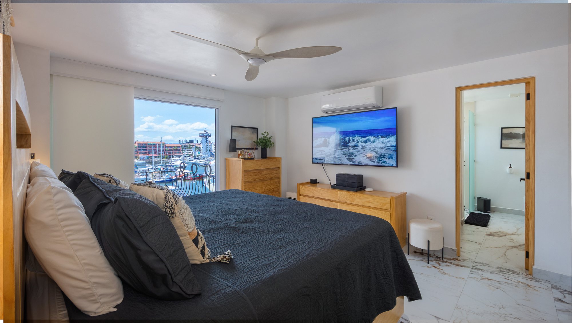 Recámara con cama king y ventana a la marina