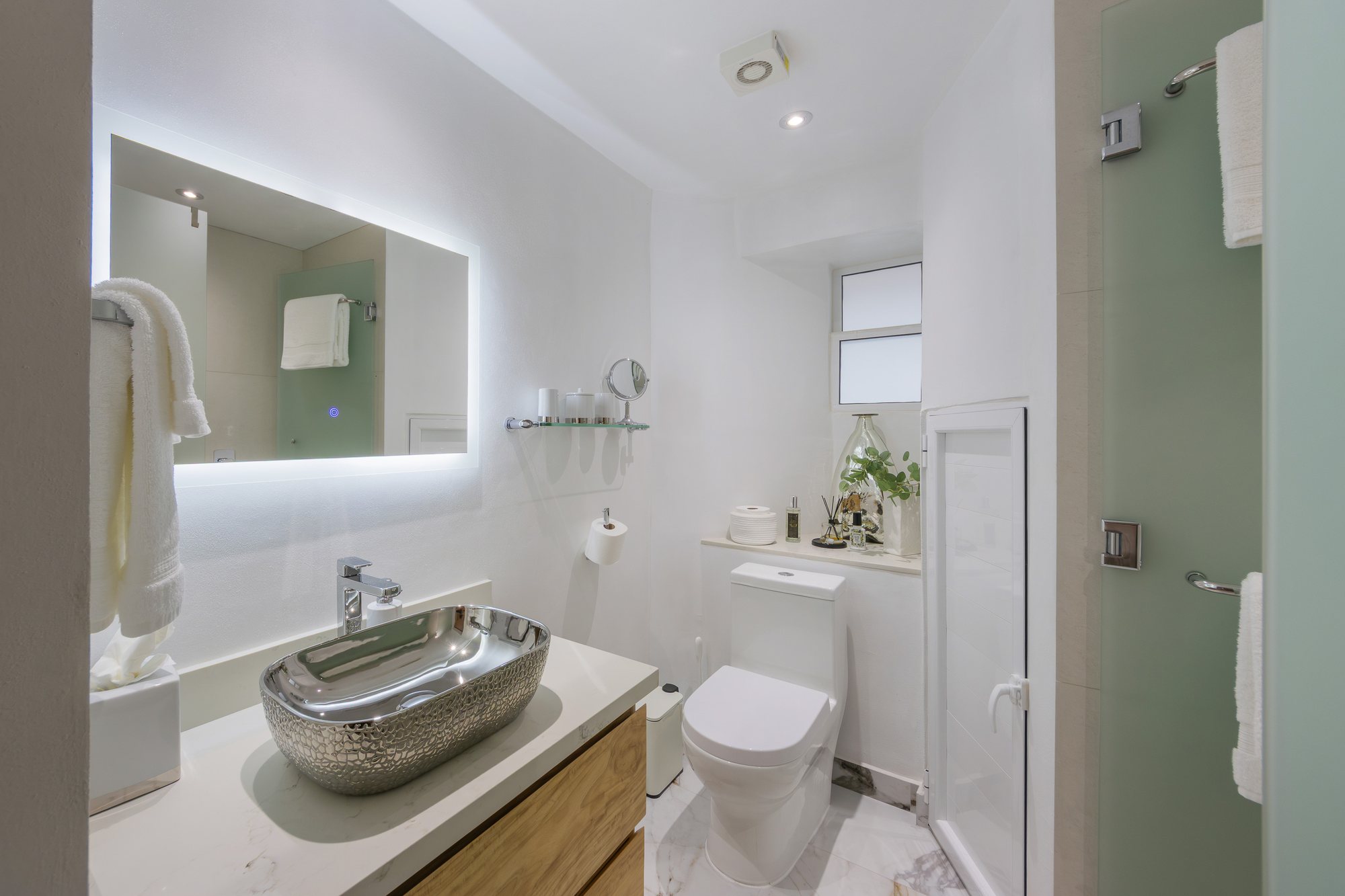 Baño con espejo iluminado y lavabo de sobreponer
