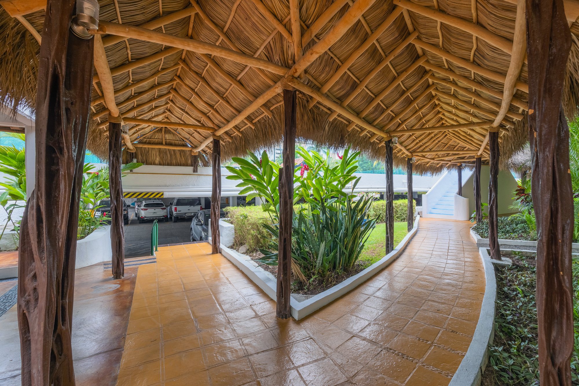 Andador con palapa entre los jardines