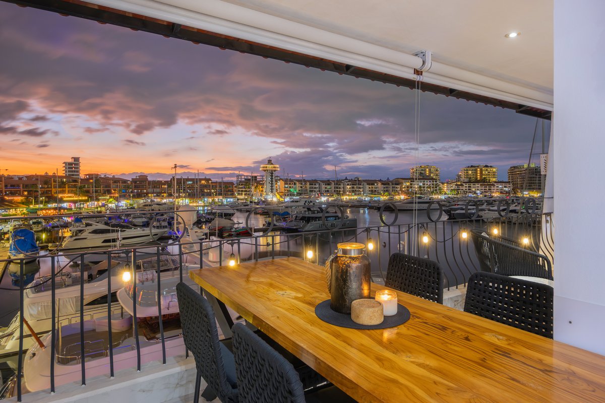 Terrace dining table at dusk above the yachts of Marina Vallarta at Marina Las Palmas 313