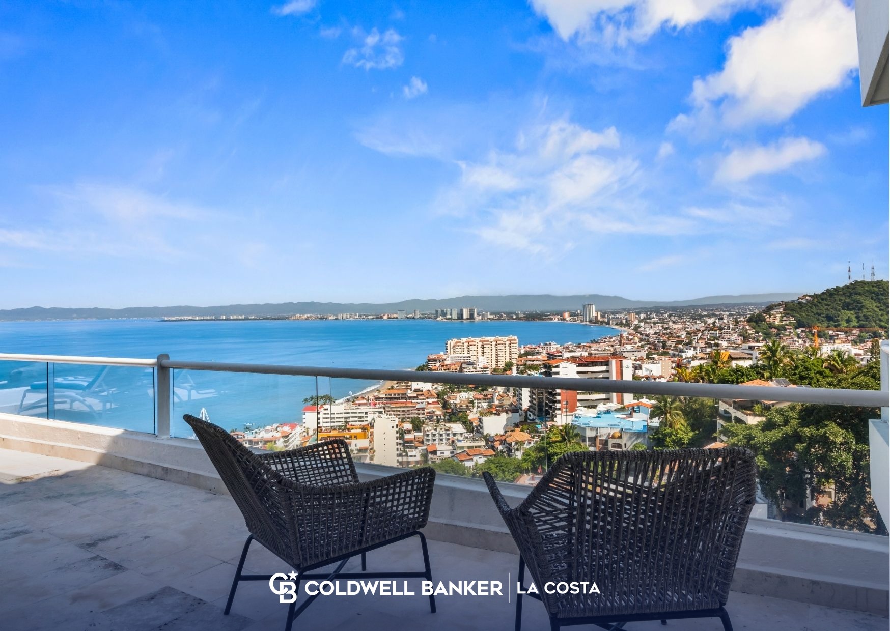 Dos sillas de patio en una terraza con vista a Puerto Vallarta y la Bah&iacute;a de Banderas, una vista que disfrutan muchos trabajadores remotos