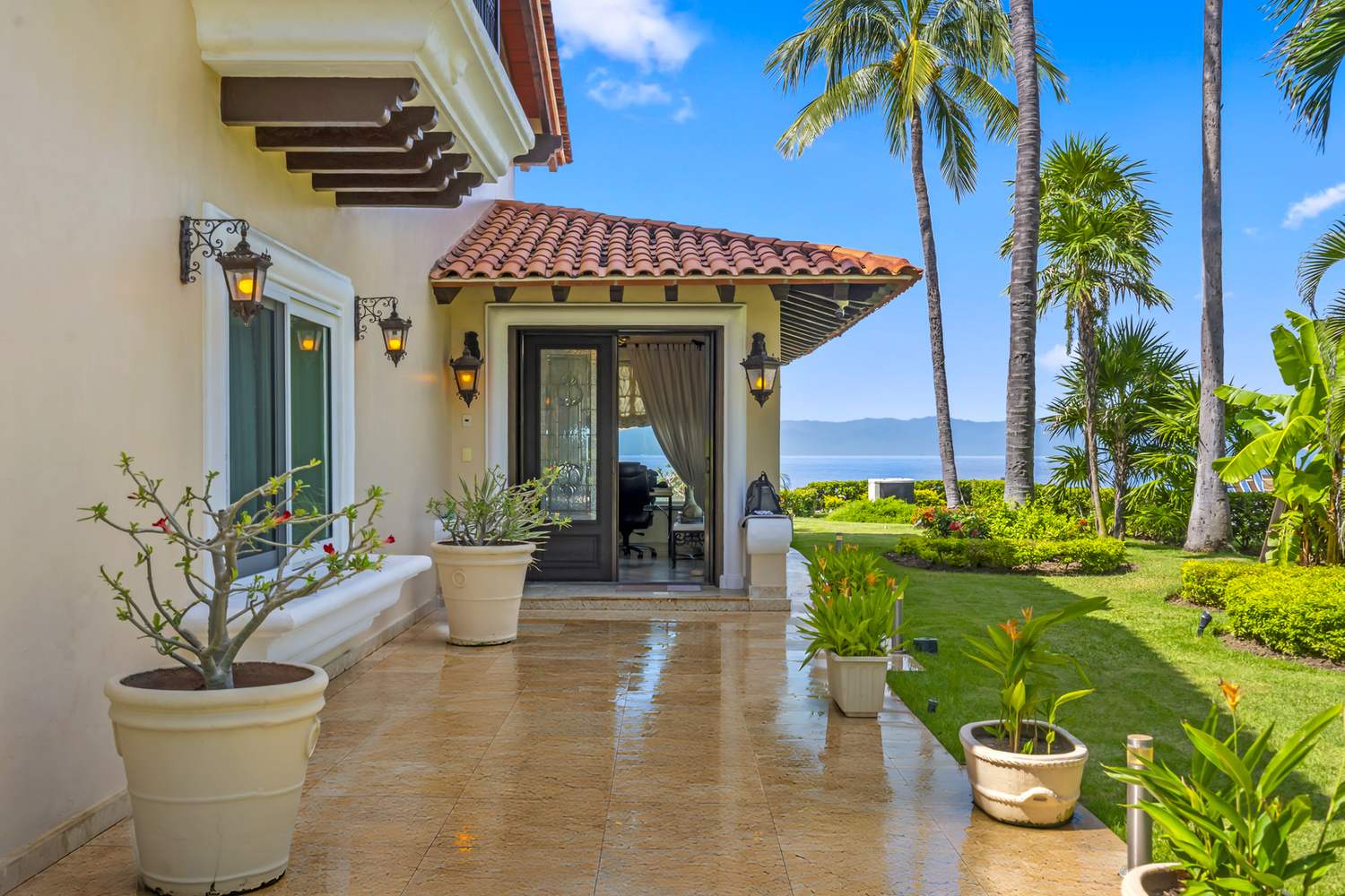 Covered entry of Villa Caracoles 1A with garden and a glimpse of the ocean