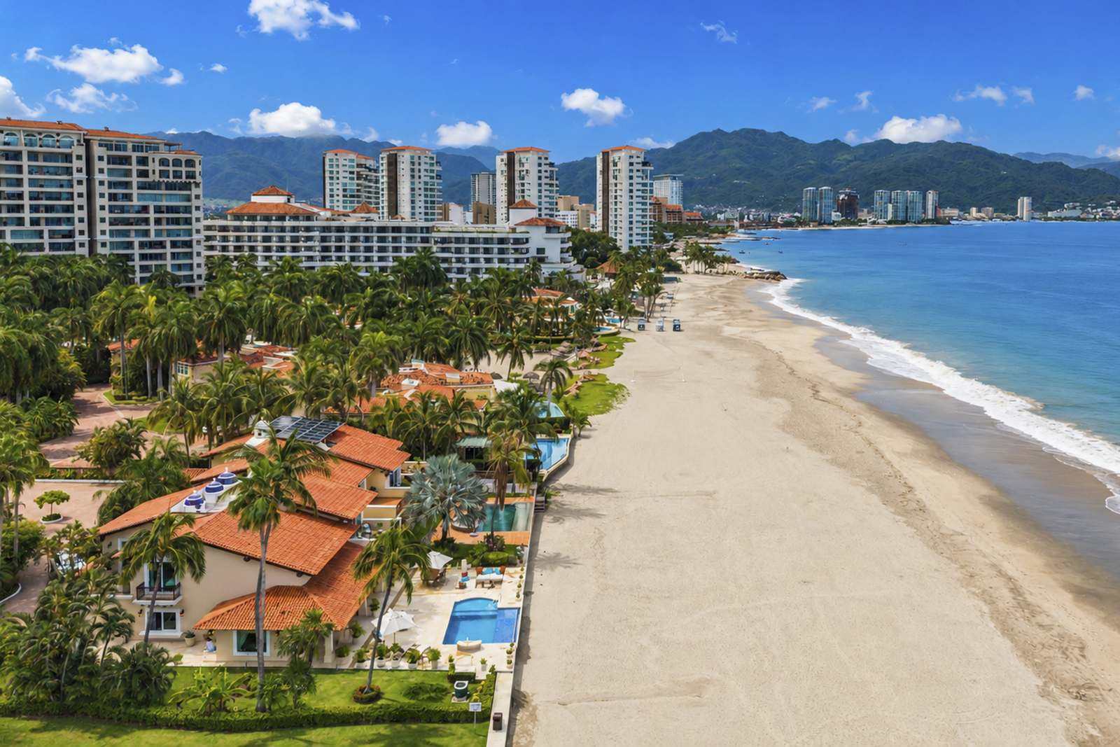 Aerial view of the sandy beach in front of Condominios Caracoles, looking toward Puerto Vallarta