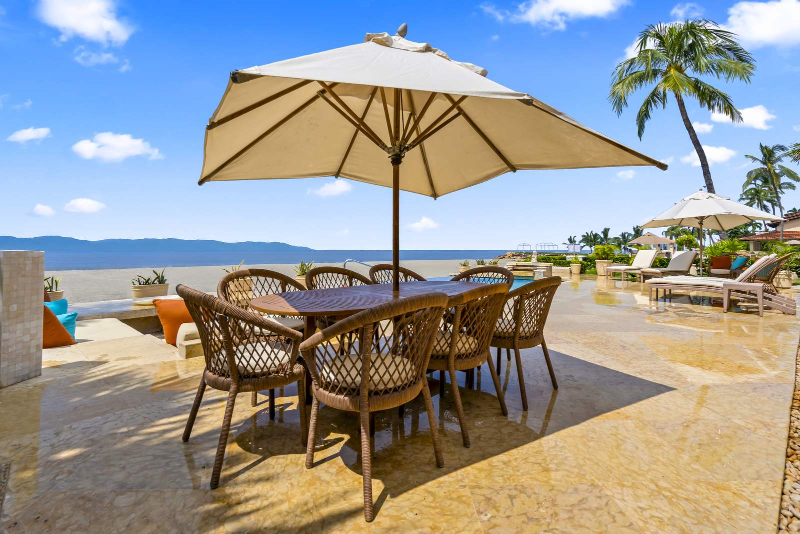 Outdoor dining under an umbrella, facing the bay