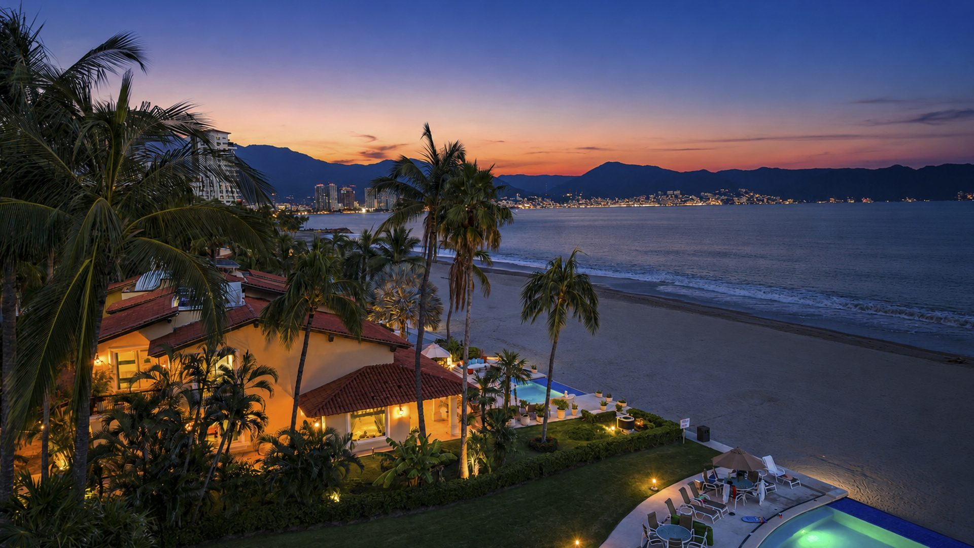 Aerial view of Villa Caracoles 1A at dusk, with the lights of Puerto Vallarta across the bay