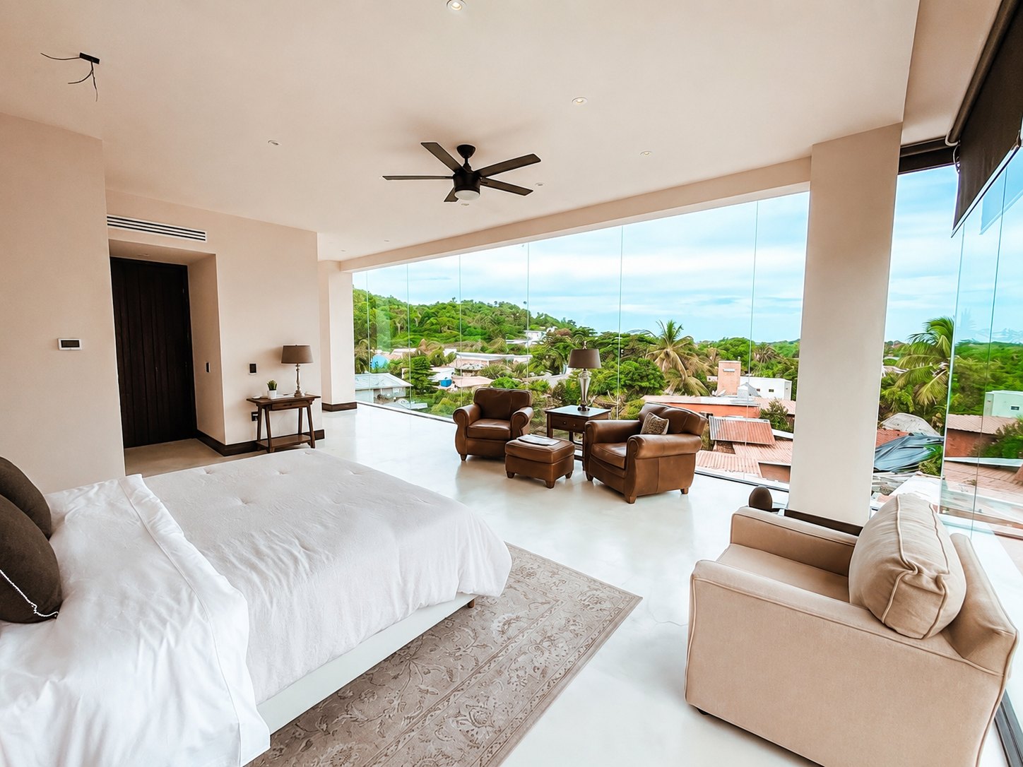 Recámara con cristal de piso a techo con vista al pueblo y la selva