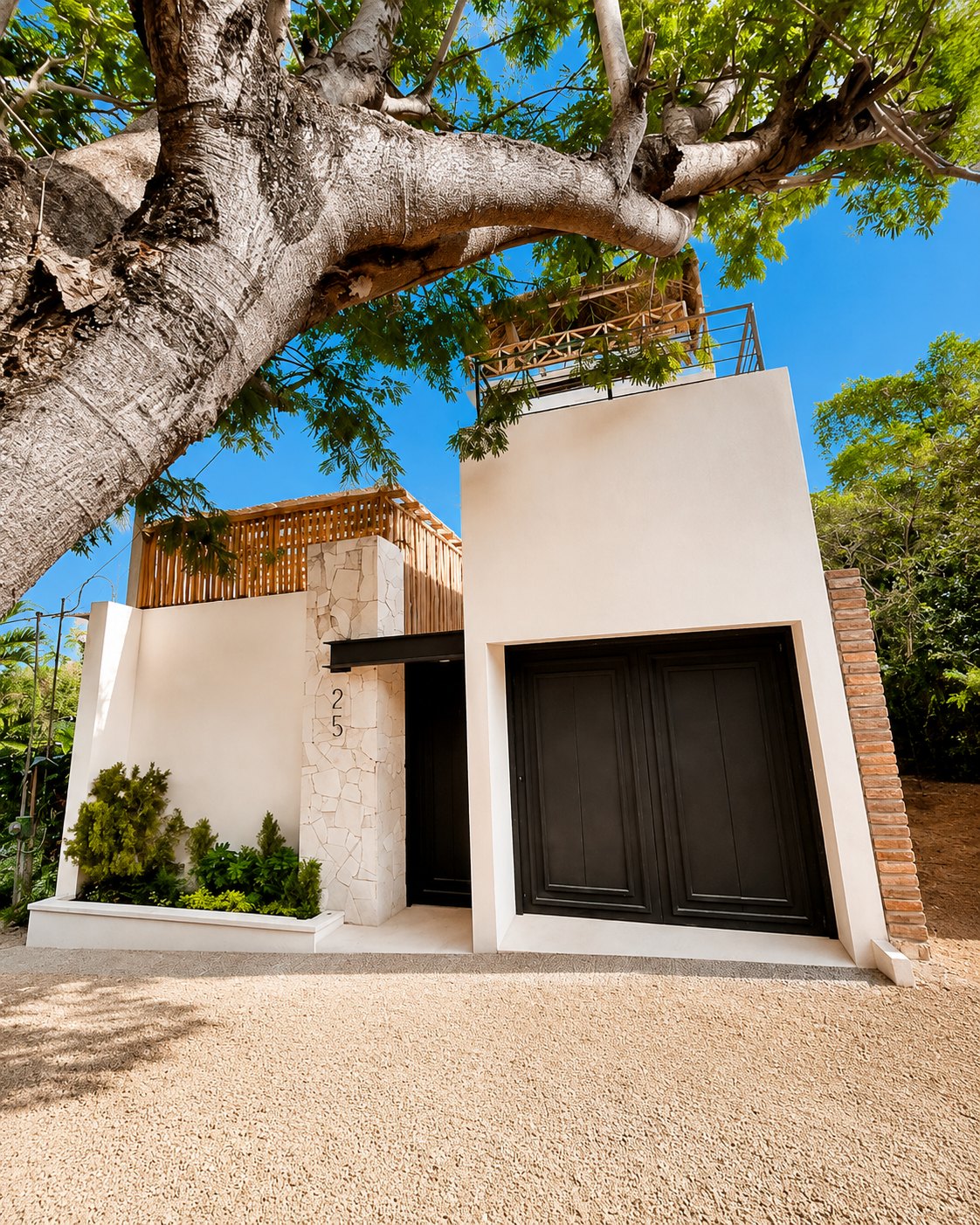 Fachada a la calle bajo un árbol de sombra