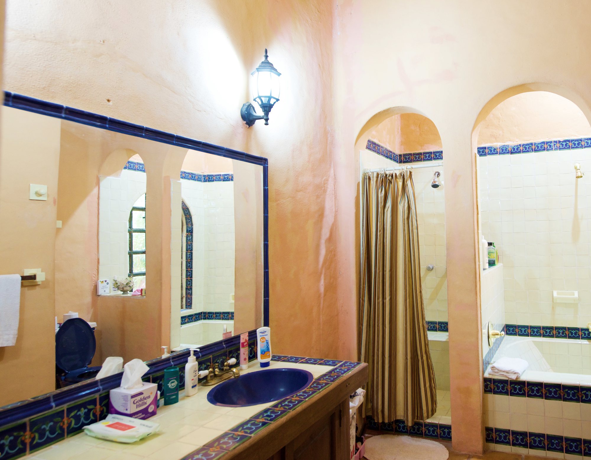 Baño con talavera y regadera bajo arco