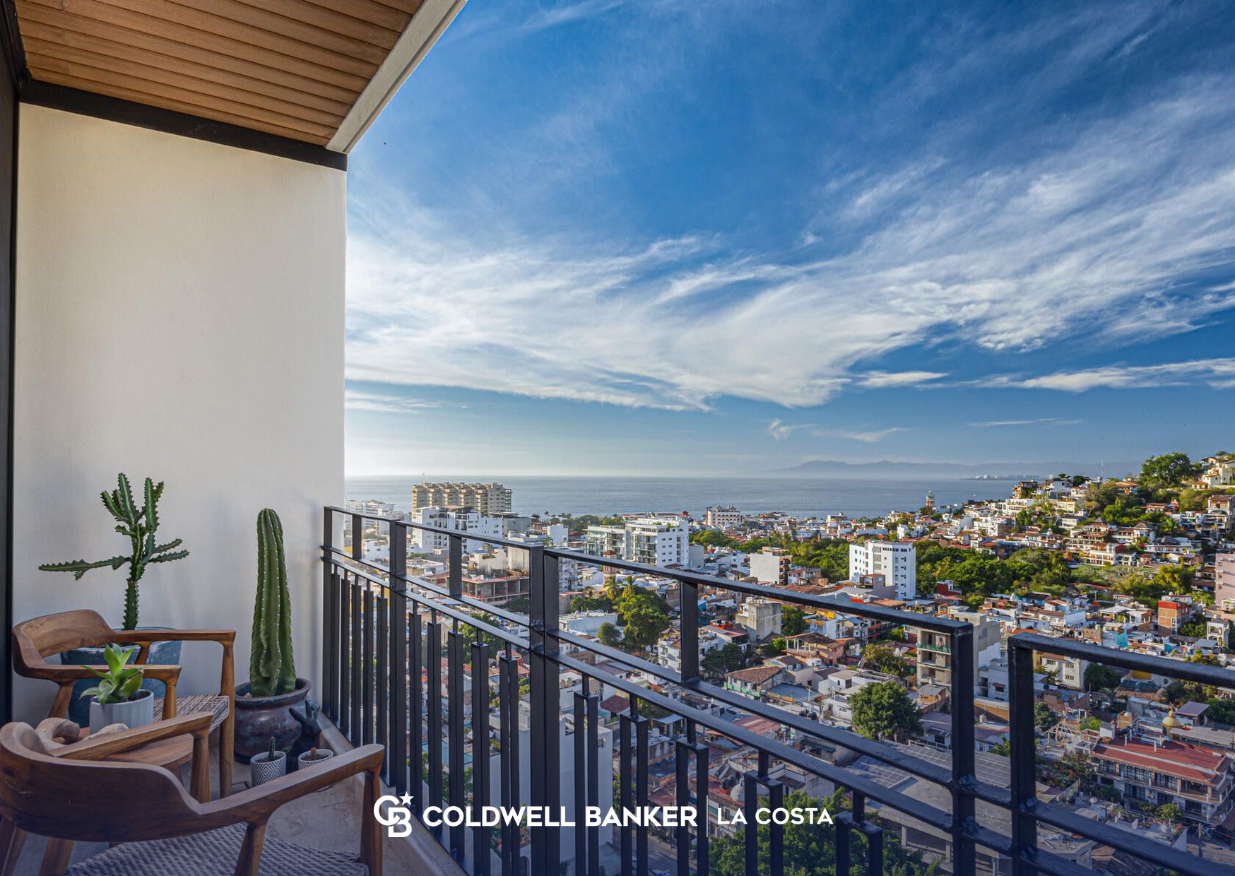Balcony with chairs overlooking the rooftops of Zona Rom&aacute;ntica toward Banderas Bay in Puerto Vallarta