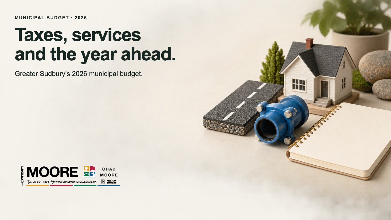 Small house model beside a miniature road, blue water pipe and notebook