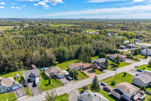 Angled aerial view of 20 Hazel Street, its lot and wooded backdrop