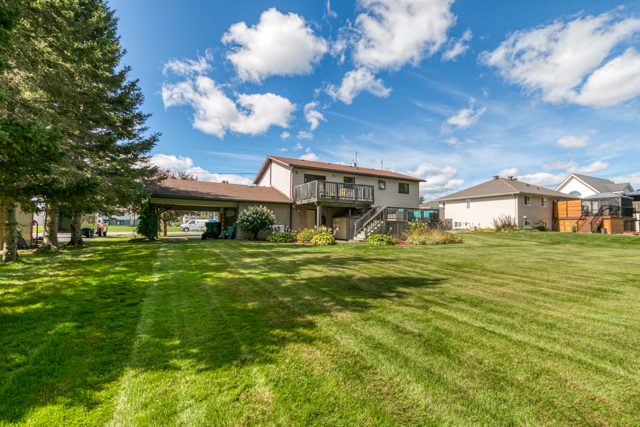 Rear exterior of the home with deck levels and lawn