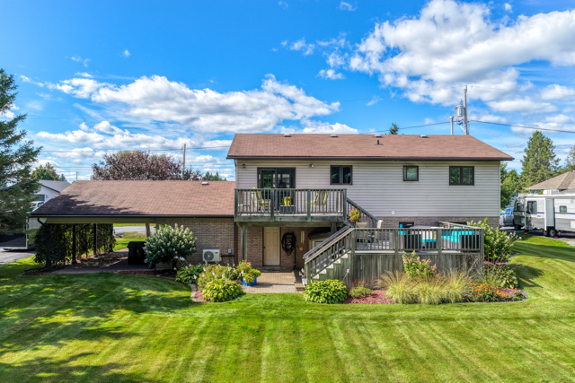 Rear of 20 Hazel Street with two deck levels, landscaped beds and lawn