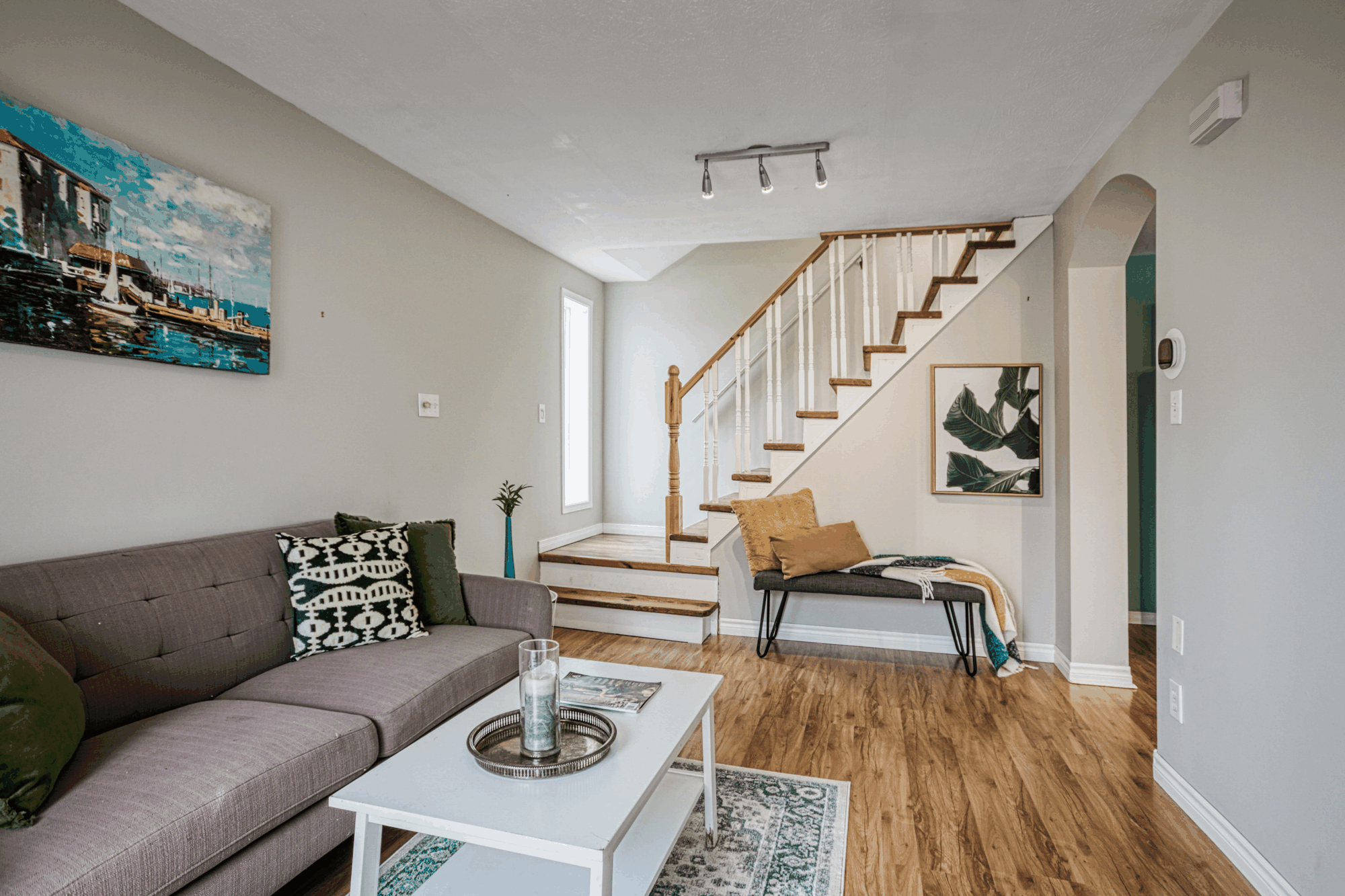 Staged living room with staircase and hardwood floor