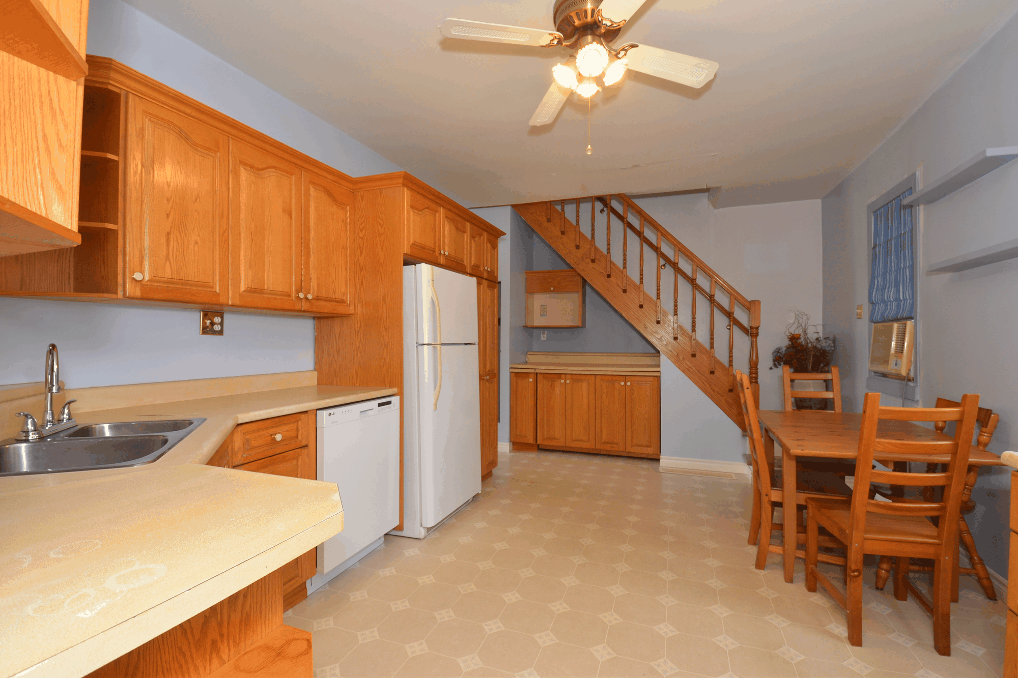 Kitchen and dining area with wood cabinetry and staircase