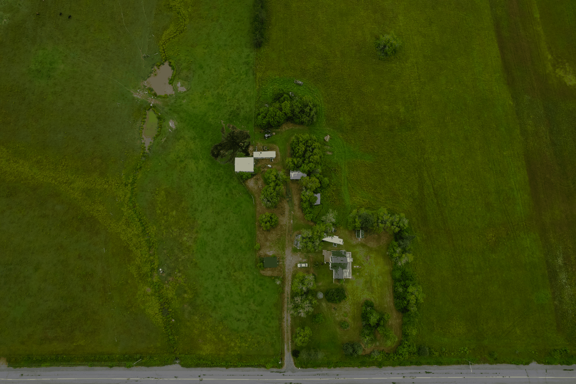 Aerial view showing the home, outbuildings and surrounding land