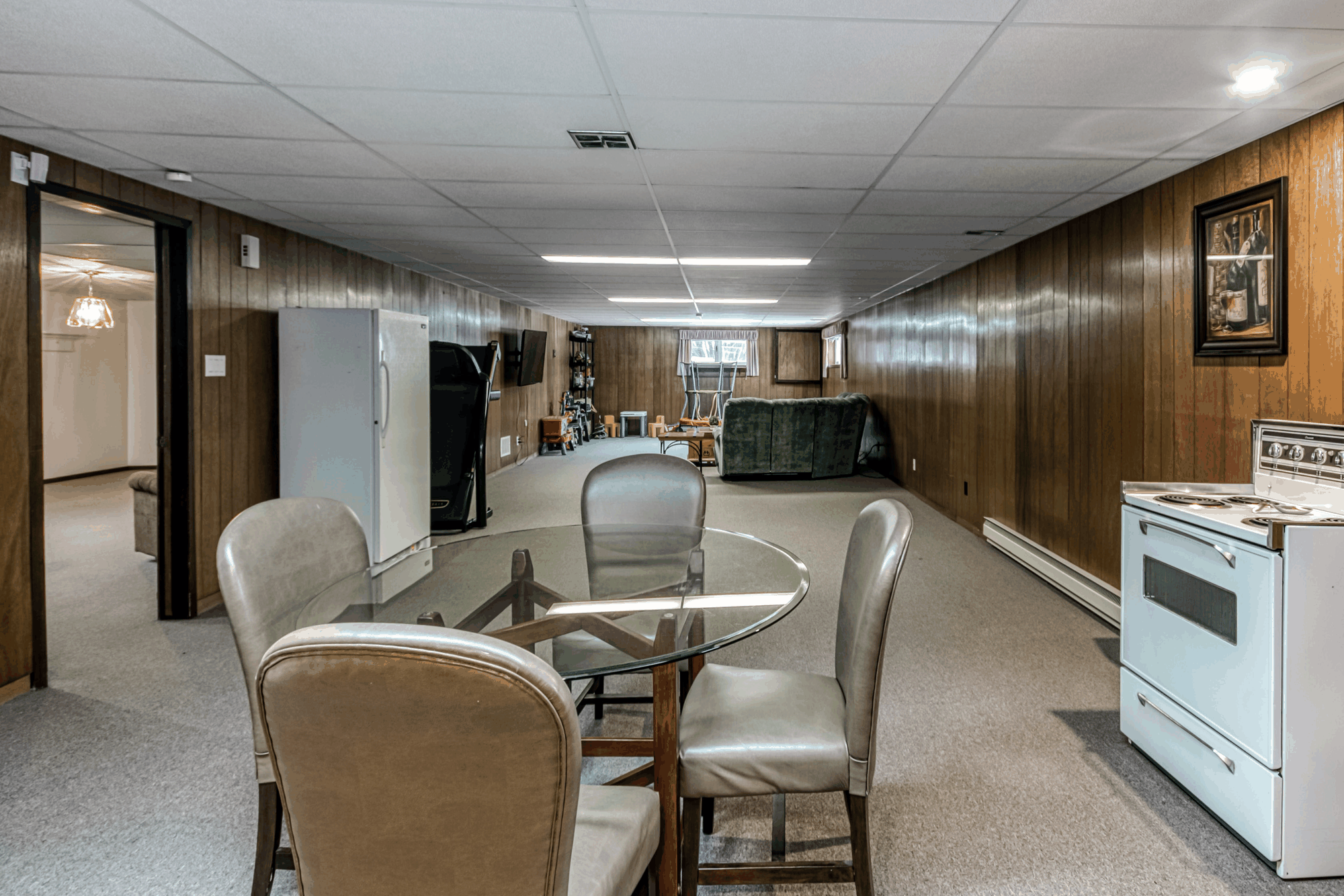 Finished lower-level living area with cabinetry and dining space