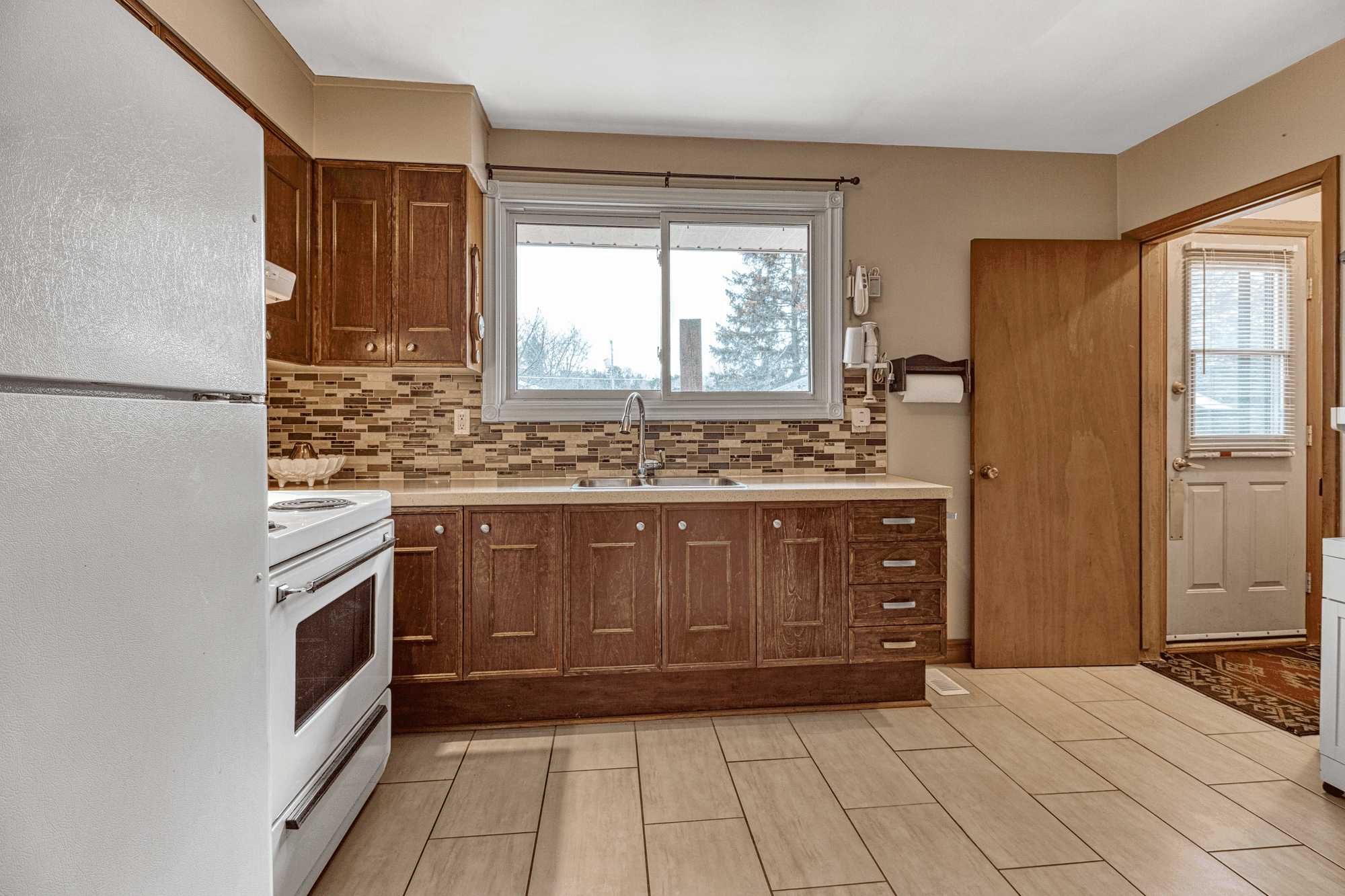 Eat-in kitchen with wood cabinetry and rear door