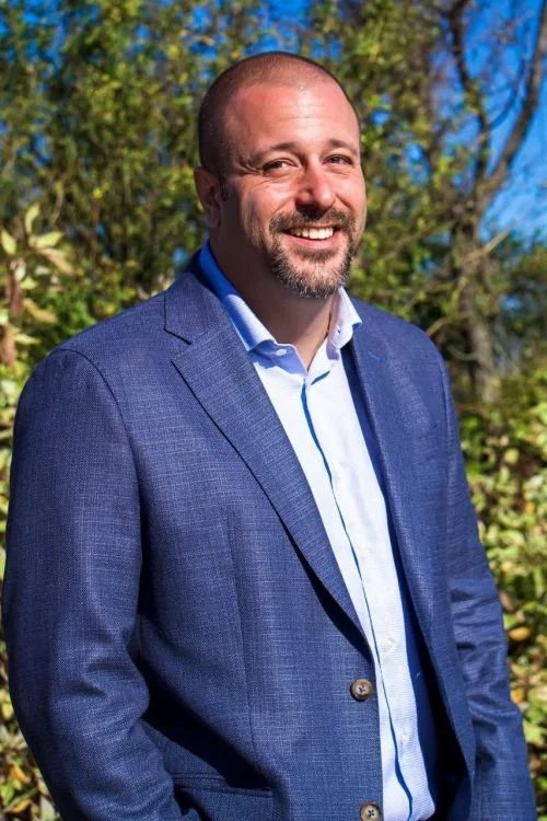 Chad Moore, REALTOR, in a blue blazer outdoors