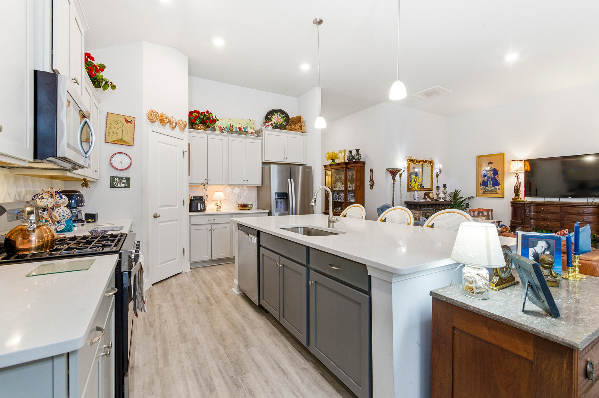 open concept living kitchen features large island stainless steel appliances gas stove and hard surface countertops