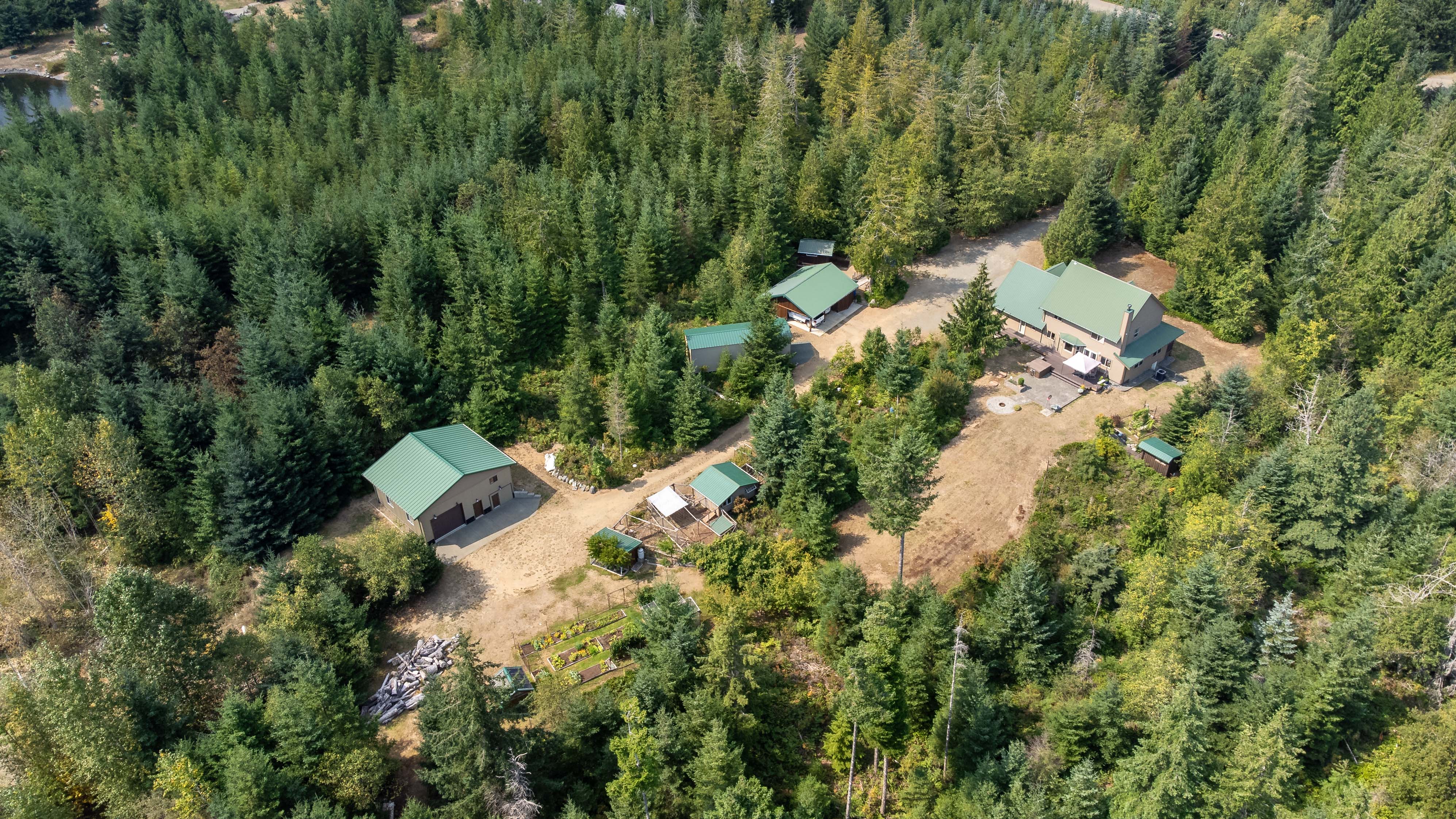 Private 5-acre Merville property at 1131 Hecker Rd featuring a meticulously maintained home, landscaped grounds, mature fruit and nut trees, fenced garden with greenhouse, detached shop, and peaceful rural surroundings.