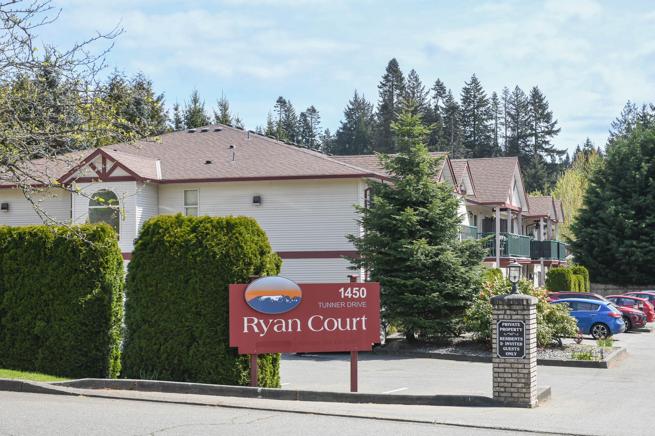 Exterior view of 106-1450 Tunner Dr in Courtenay, BC, showcasing a well-maintained condo building in the desirable Ryan Court community with landscaped grounds and convenient ground-floor access&mdash;highlighting affordable Courtenay real estate close to shopping, schools, CFB Comox, and everyday amenities in the Comox Valley.