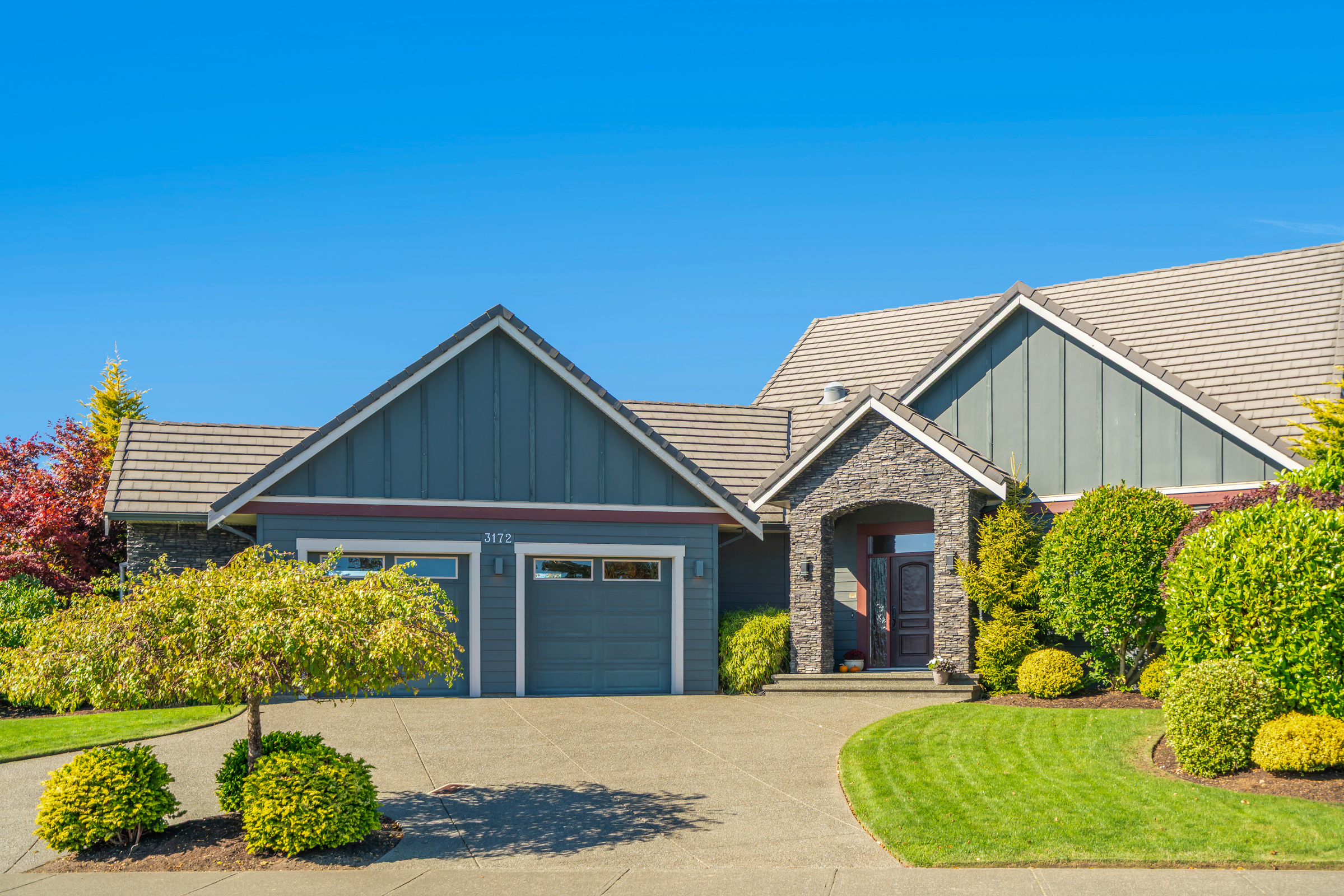 Luxury Crown Isle residence at 3172 Royal Vista Way featuring 165 feet of golf course frontage, panoramic fairway and mountain views, manicured landscaping and elegant custom-home design.