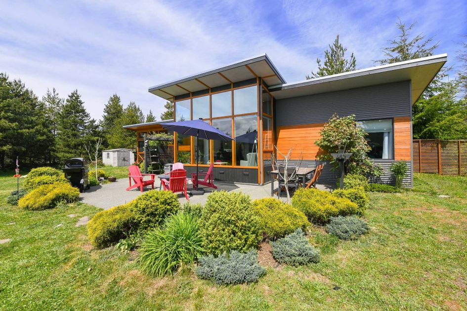 Beautiful contemporary home at 4131 Pinecrest Rd on Denman Island, featuring 11&rsquo; timber frame windows, a cozy wood-burning fireplace, and over 5 acres of private, park-like property.