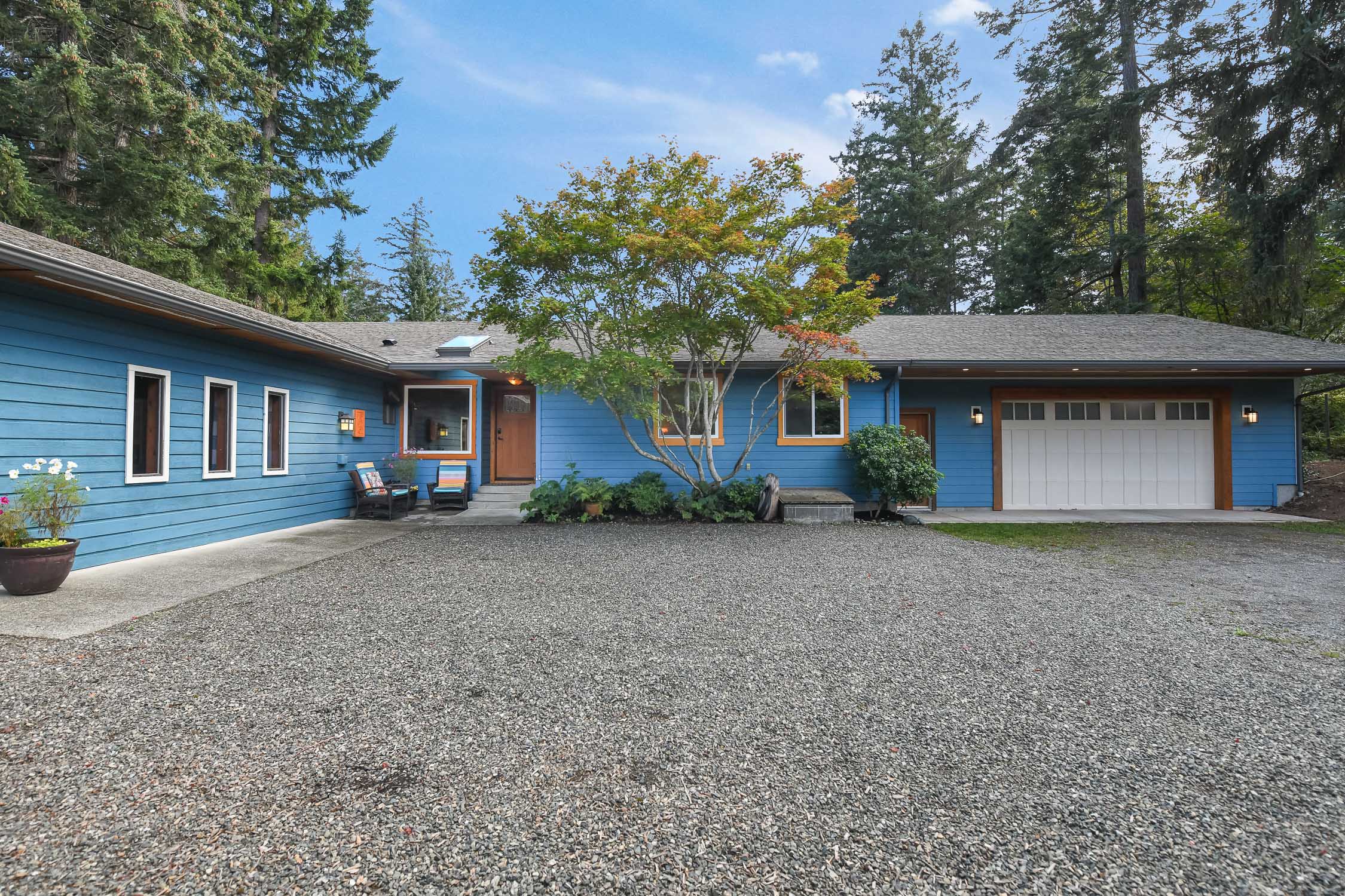 Beautifully renovated 2,000 sq. ft. rancher at 606 Colby Rd in Comox, set on a private 0.70-acre park-like property backing onto the Northeast Woods with mature natural surroundings.