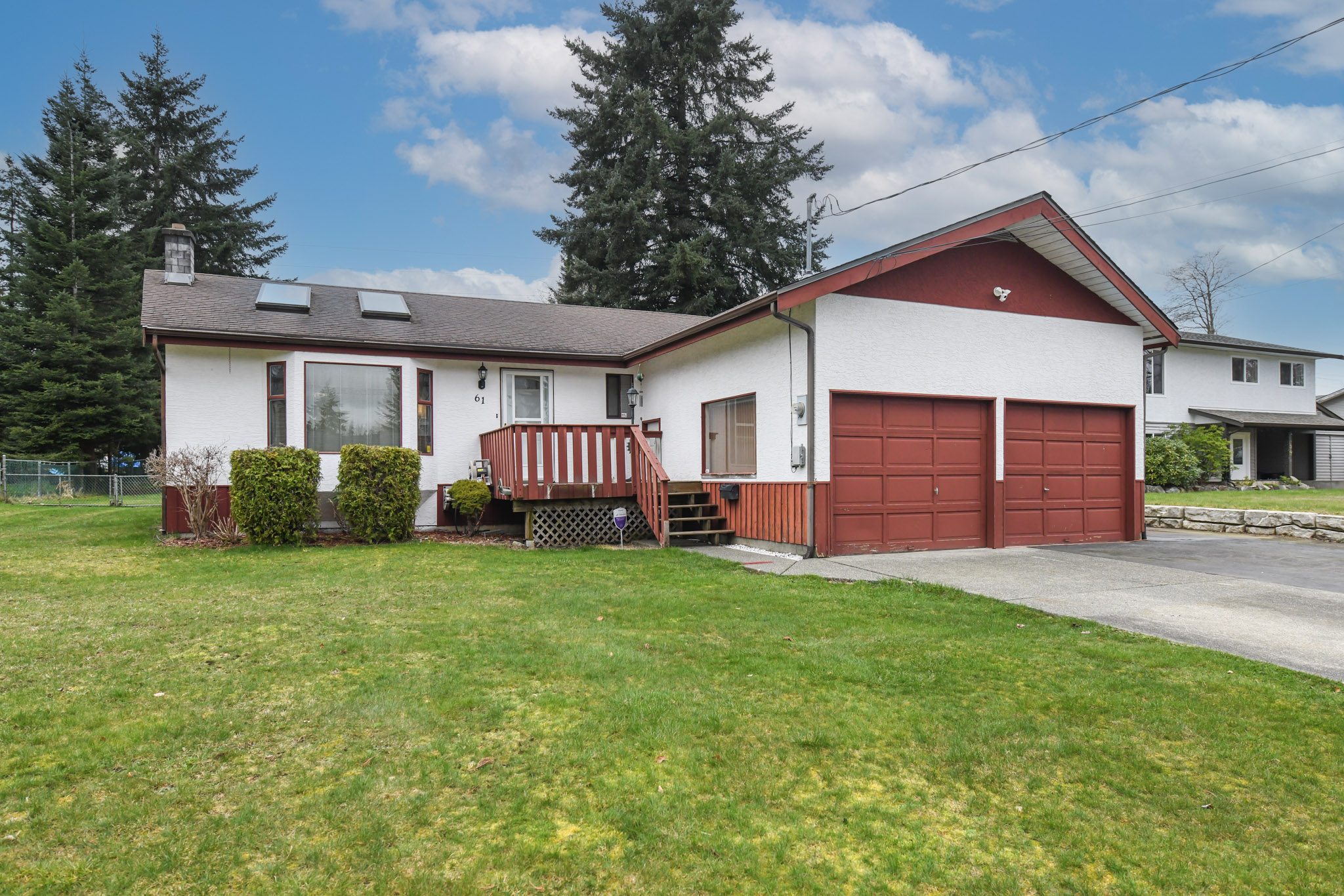 Front exterior view of 61 Salsbury Rd in Courtenay, BC, showcasing a well-maintained rancher on a spacious 0.34-acre lot with mature landscaping, double garage, and RV parking&mdash;highlighting desirable West Courtenay real estate near the Puntledge River, walking trails, and everyday amenities in the Comox Valley.
