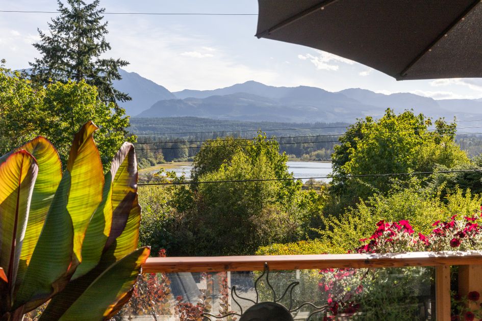 Expansive southwest-facing deck at 7692 Tozer Rd, Fanny Bay, BC overlooking the ocean, Beaufort Mountains, and nearby bird sanctuary. Perfect spot to enjoy sunsets, entertain guests, and take in stunning Vancouver Island views.