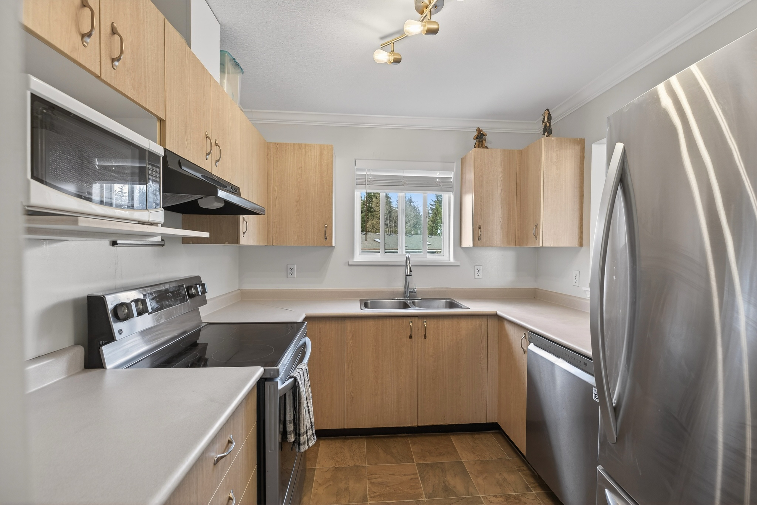 Exterior view of 401-840 Braidwood Rd in Courtenay, BC, showcasing the Five Oaks Villa condo complex in a desirable central location—highlighting affordable Courtenay real estate with top-floor living, mountain views, and convenient access to shopping, restaurants, parks, and everyday amenities.