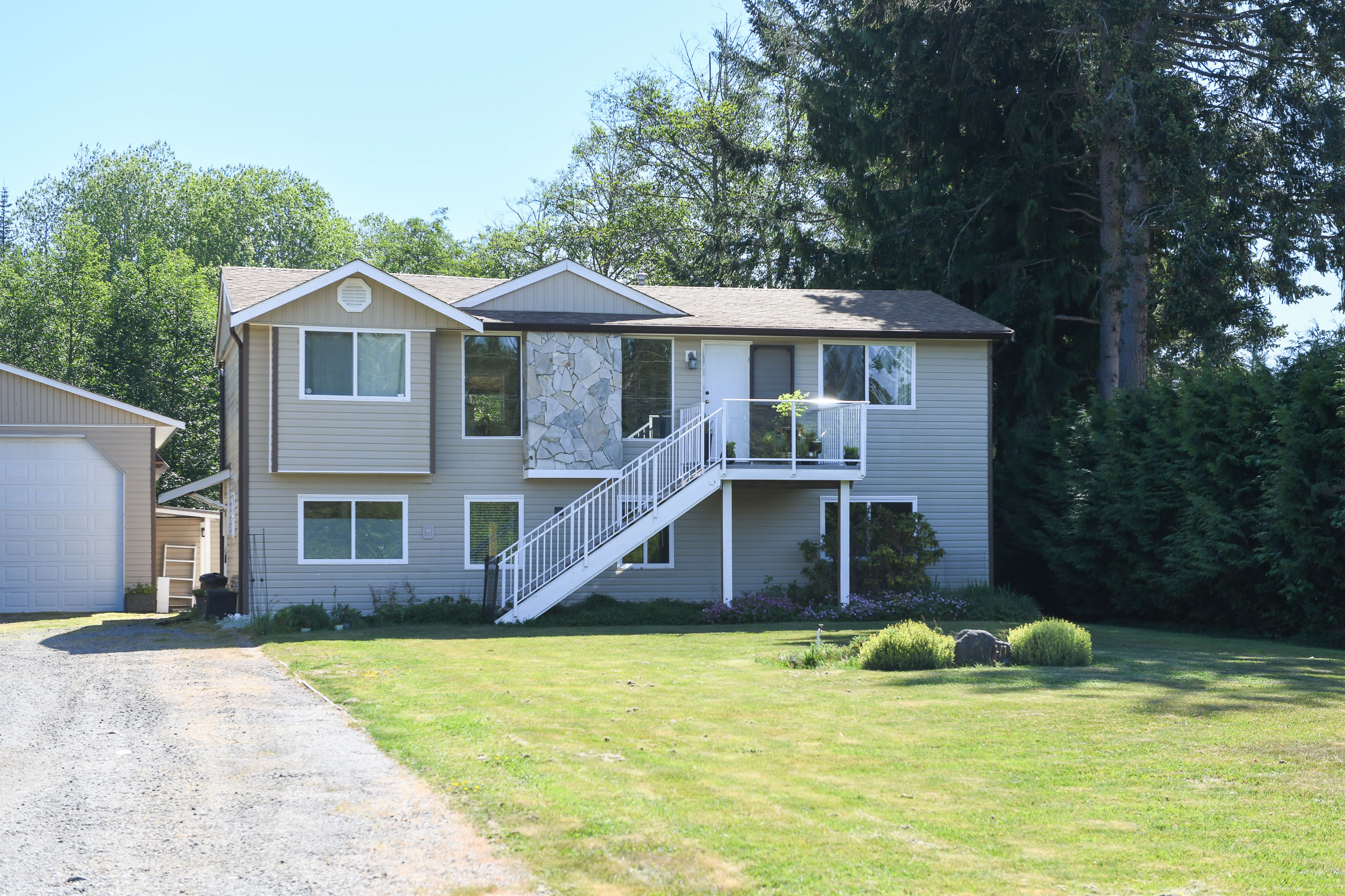 Income-producing property at 1804 Little River Rd in Comox featuring a legal 2-bedroom suite, wired workshop, mature landscaped gardens, and exceptional privacy near beaches and CFB Comox.