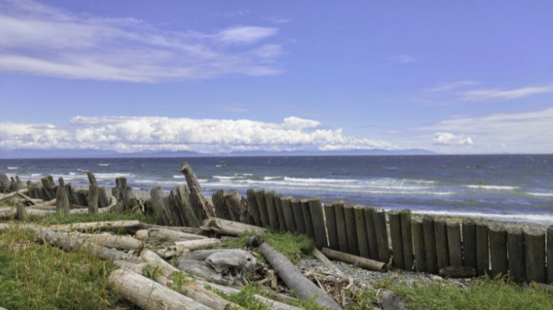 Scenic view of Goose Spit beach in the Comox Valley, Vancouver Island, showcasing sandy shoreline, ocean waters, and mountain backdrop &mdash; a popular local destination for walking, kayaking, and sunset views.