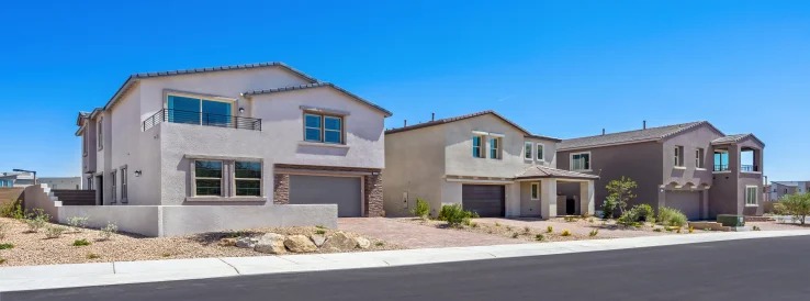 Street of two-story homes with desert landscaping at Mockingbird by Lennar