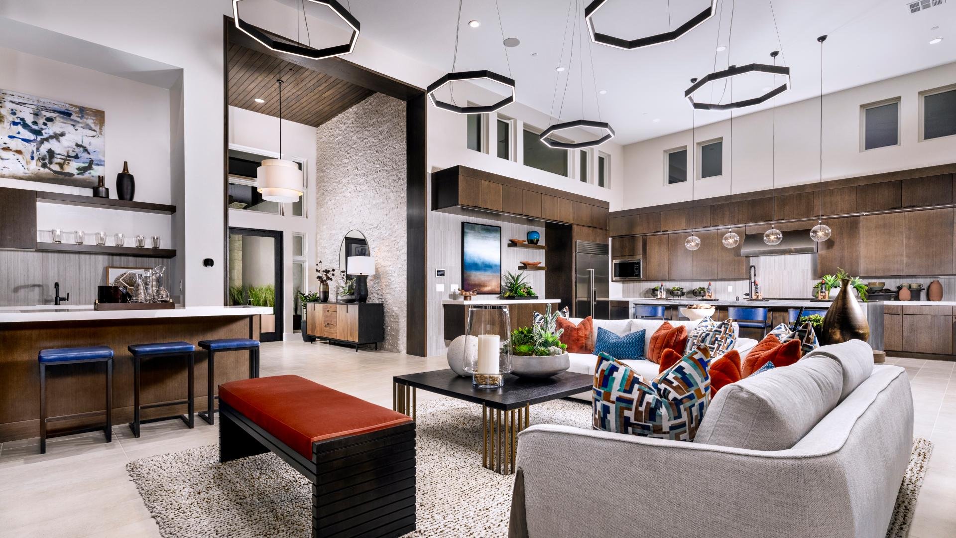 Open great room and kitchen with modern pendant lighting in a Toll Brothers model home
