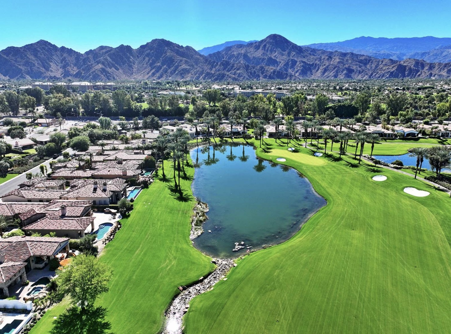 Aerial view of Toscana Country Club in Indian Wells, showing golf course, lake and Santa Rosa Mountains