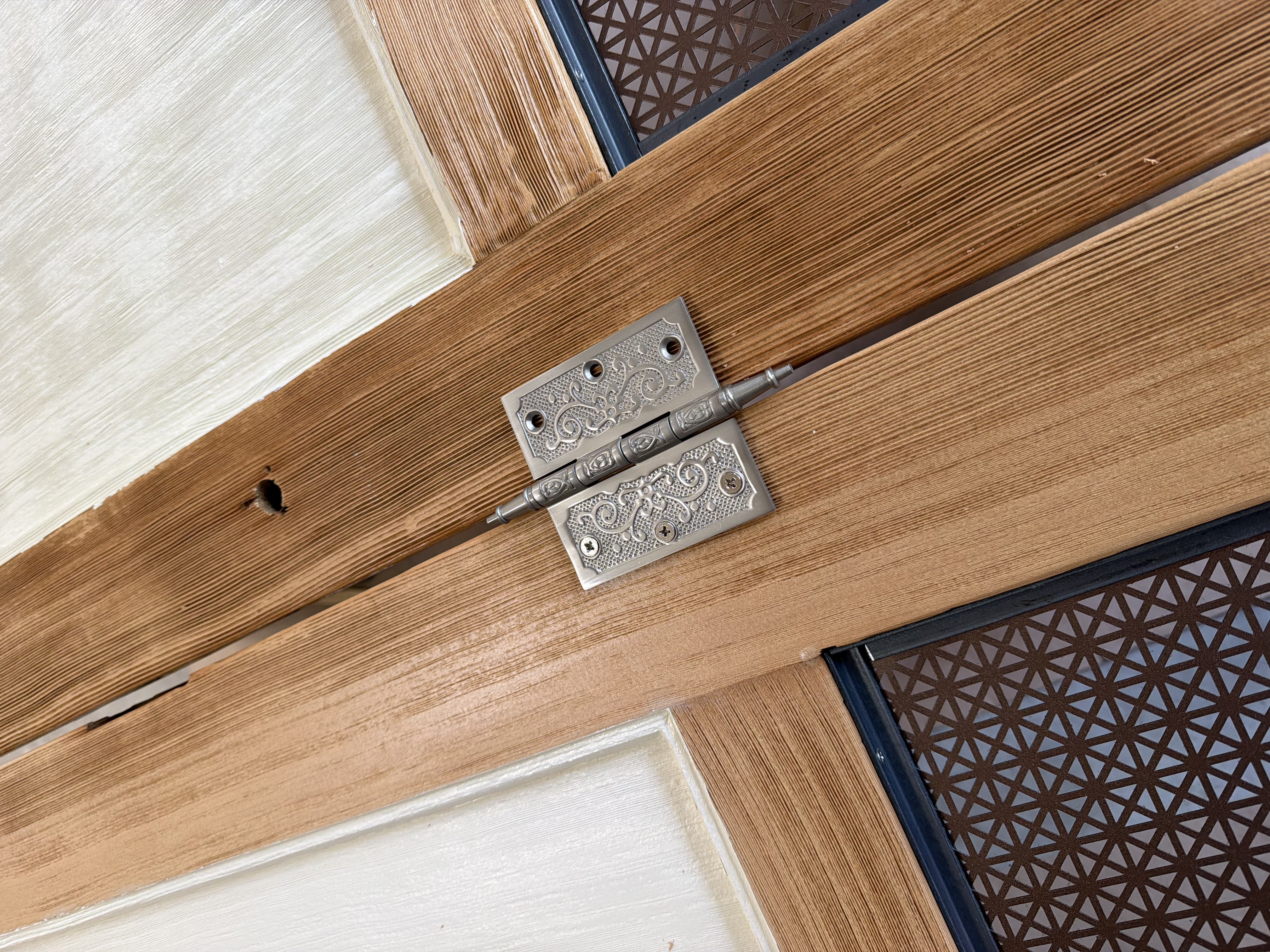 Ornate hinges holding the door panel room divider together