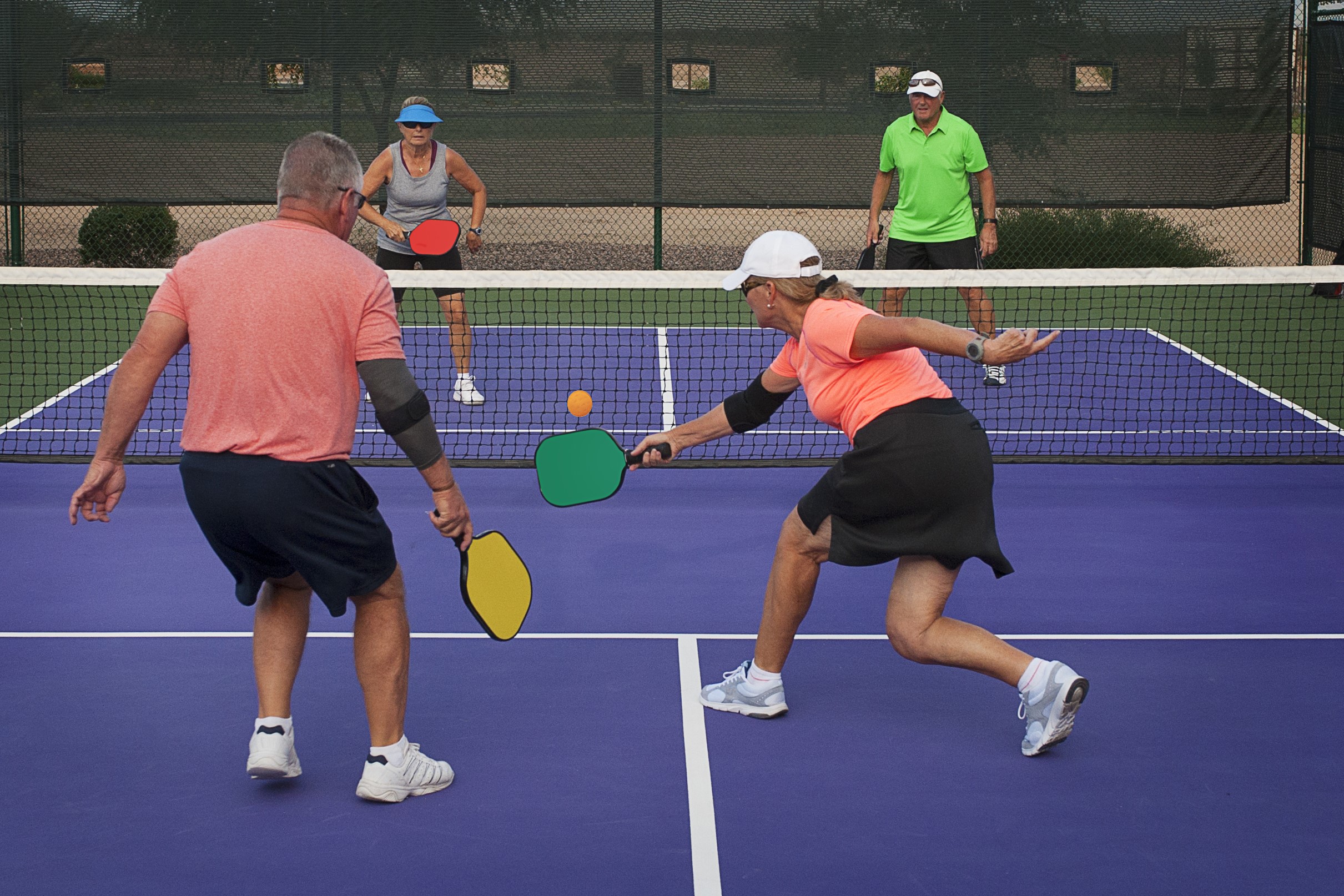 4 active adults playing pickleball